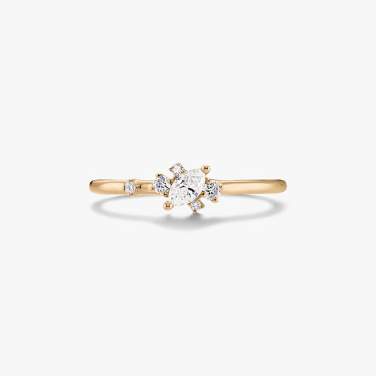 Thin 14K yellow gold ring with a marquise‑cut center diamond and small round accent diamonds on a white background.