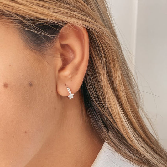Gros plan sur une oreille portant les boucles d'oreilles Estella en argent avec zircon