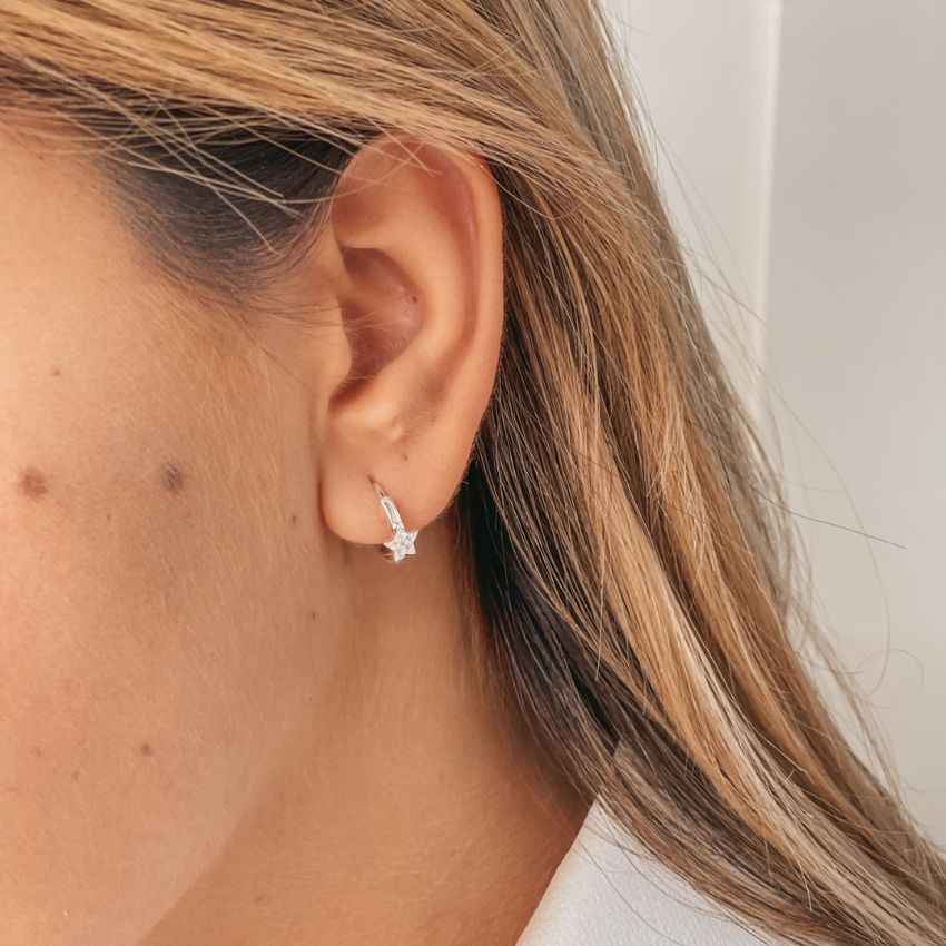 Gros plan sur une oreille portant les boucles d'oreilles Estella en argent avec zircon