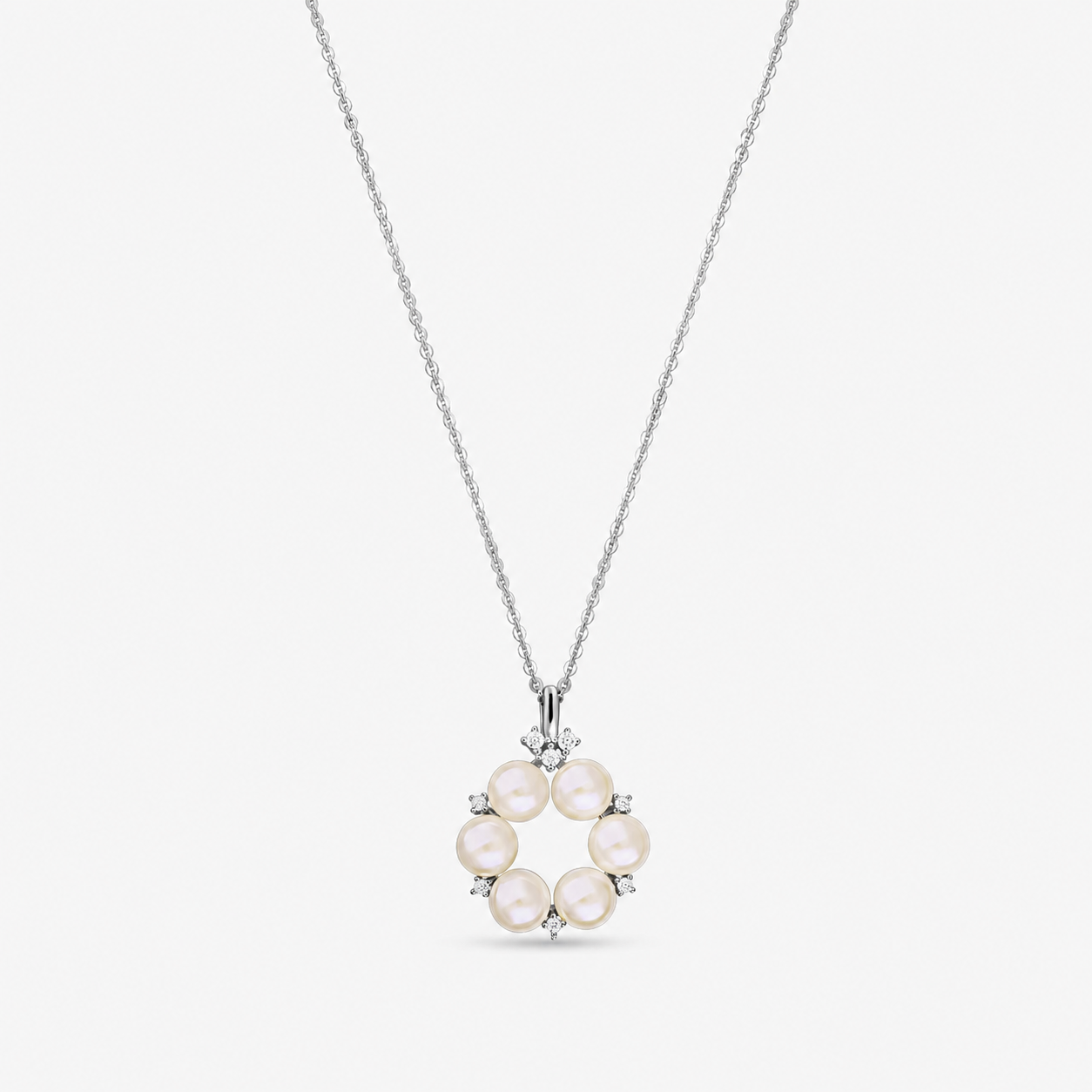 Elegáns sterling ezüst nyaklánc kör alakú medállal, hat természetes gyönggyel és apró fehér cirkóniákkal díszítve, finom láncon, fehér háttér előtt.