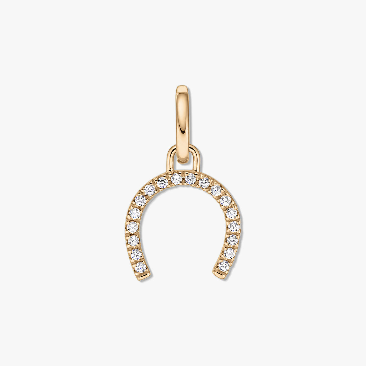 Pendentif en argent en forme de fer à cheval doré avec des pierres de zircone claire pavées sur fond blanc.