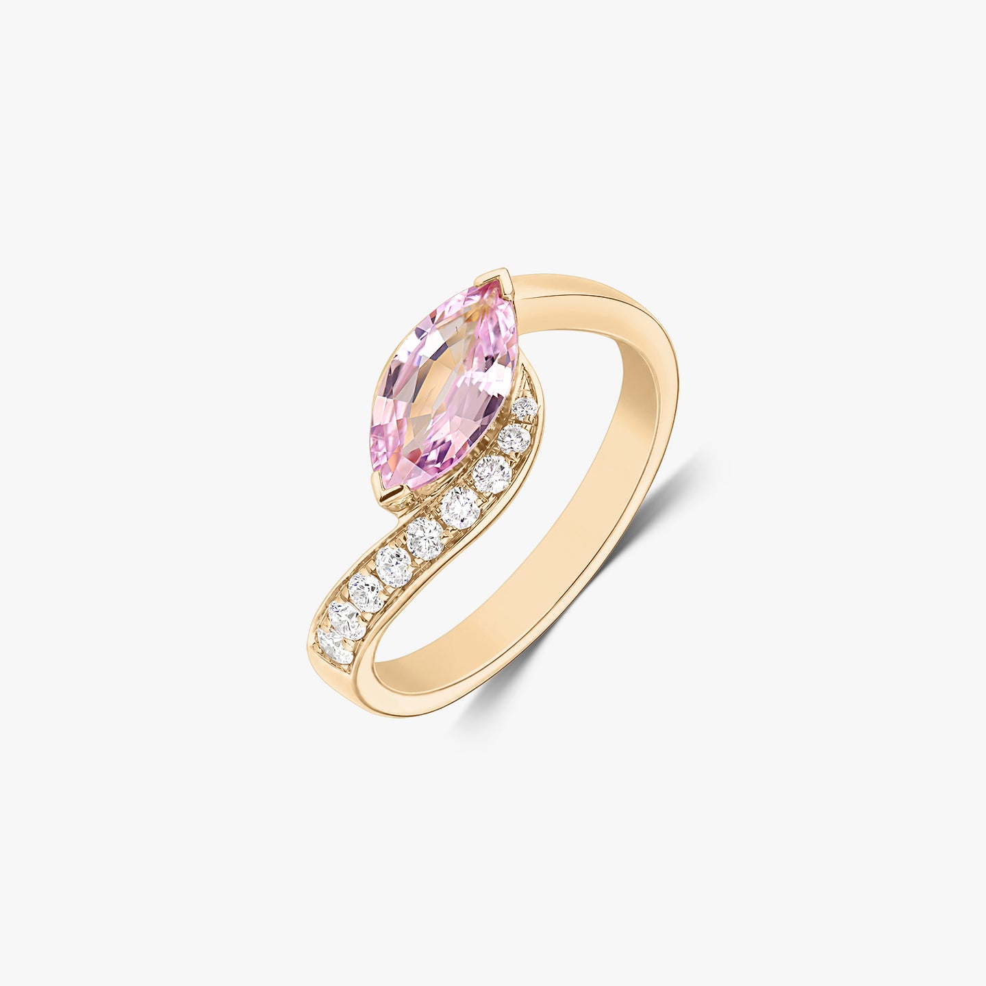 Bague bypass en or jaune 14K avec un saphir rose taille marquise et une rangée de diamants naturels, isolée sur fond blanc.