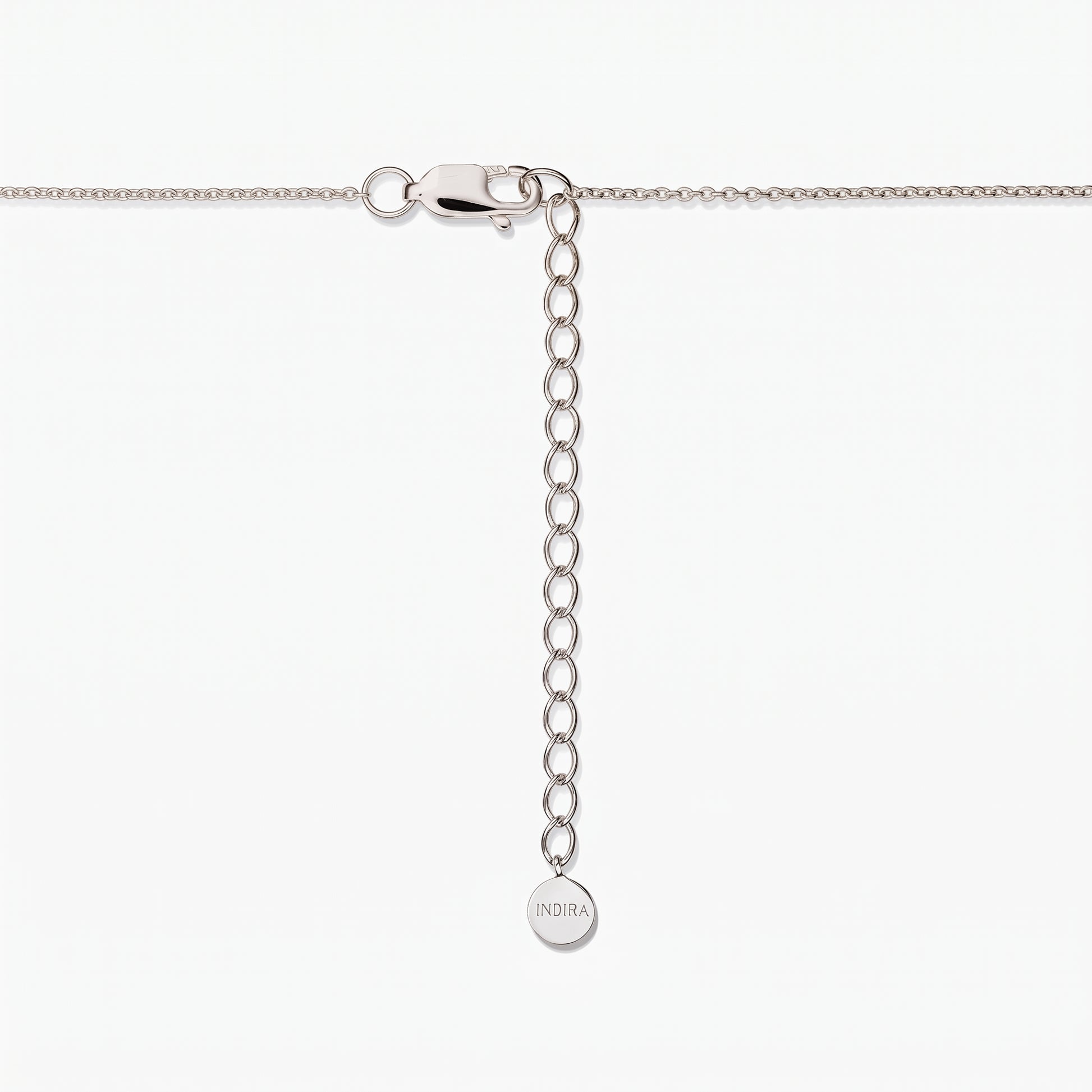 Close-up of a sterling silver necklace clasp with adjustable extender chain and a small round Indira tag on a white background.