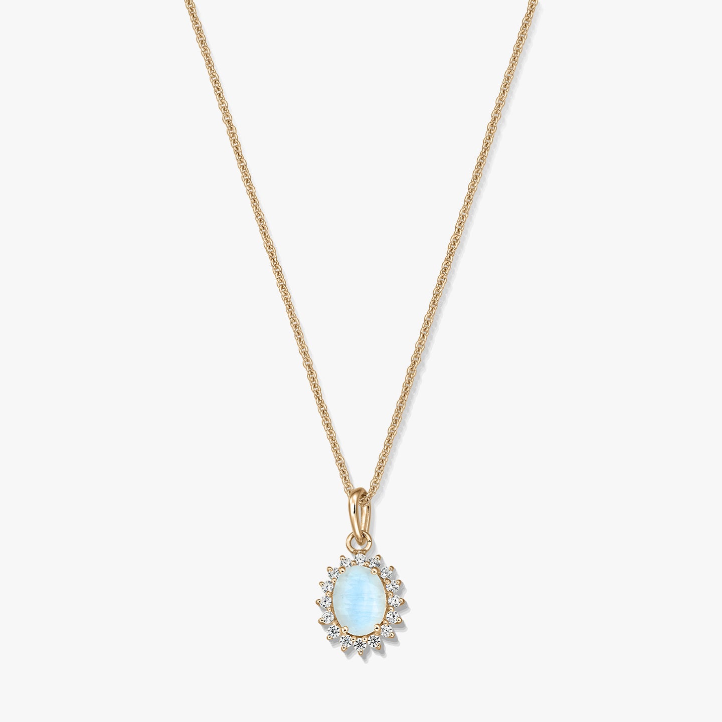 Gold‑plated sterling silver necklace with an oval light‑blue moonstone pendant framed by small clear stones on a white background.