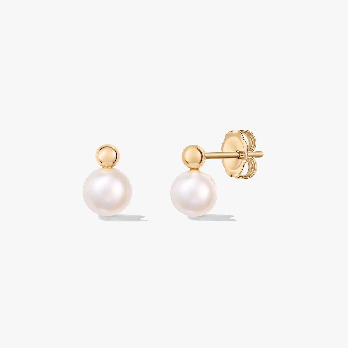 Paire de clous d’oreilles en perles de culture, tiges en argent et fermoirs papillon, sur fond blanc.