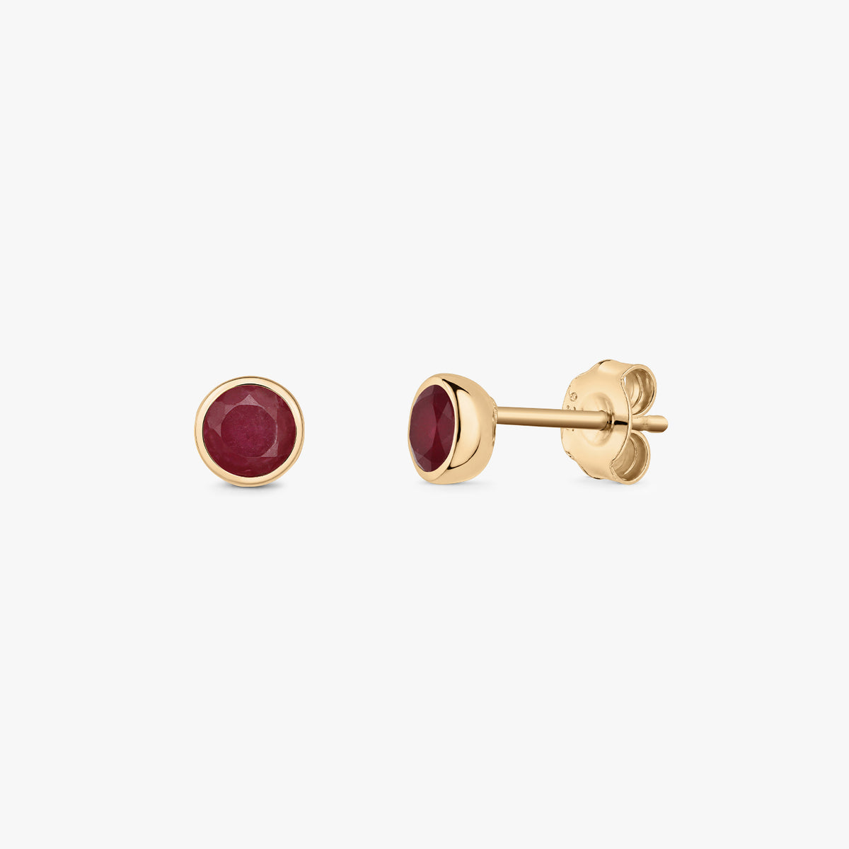 Pair of silver ruby birthstone stud earrings with round bezel settings on a white background.