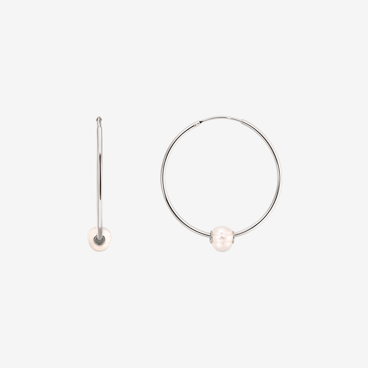 Pair of sterling silver hoop earrings each adorned with a single white cultured pearl, displayed on a white background with one earring shown from the front and the other from the side.