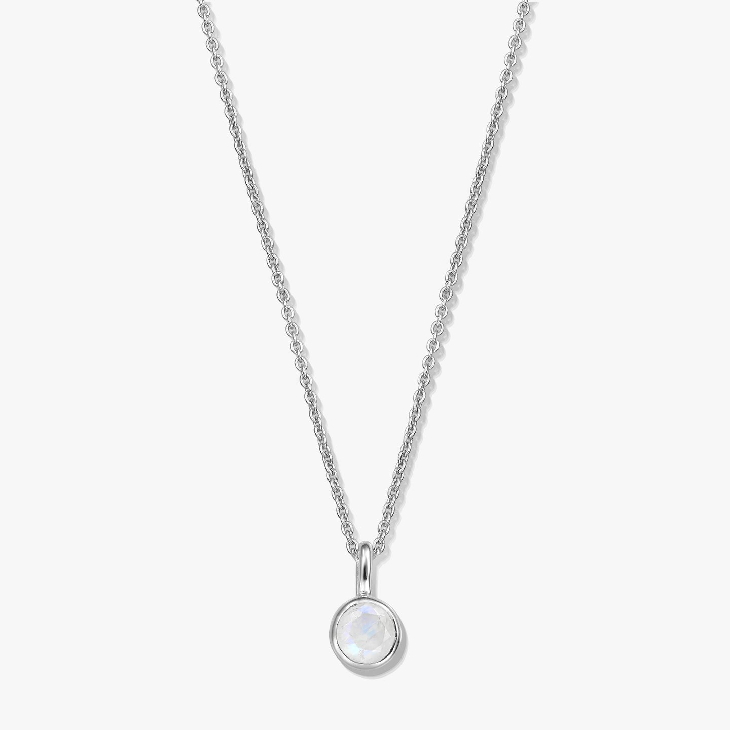 Elegant sterling silver birthstone necklace featuring a round bezel-set moonstone pendant on a fine chain, photographed on a white background.