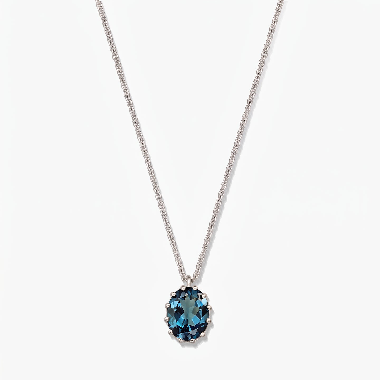 Elegant sterling silver necklace featuring an oval London blue topaz pendant on a white background.