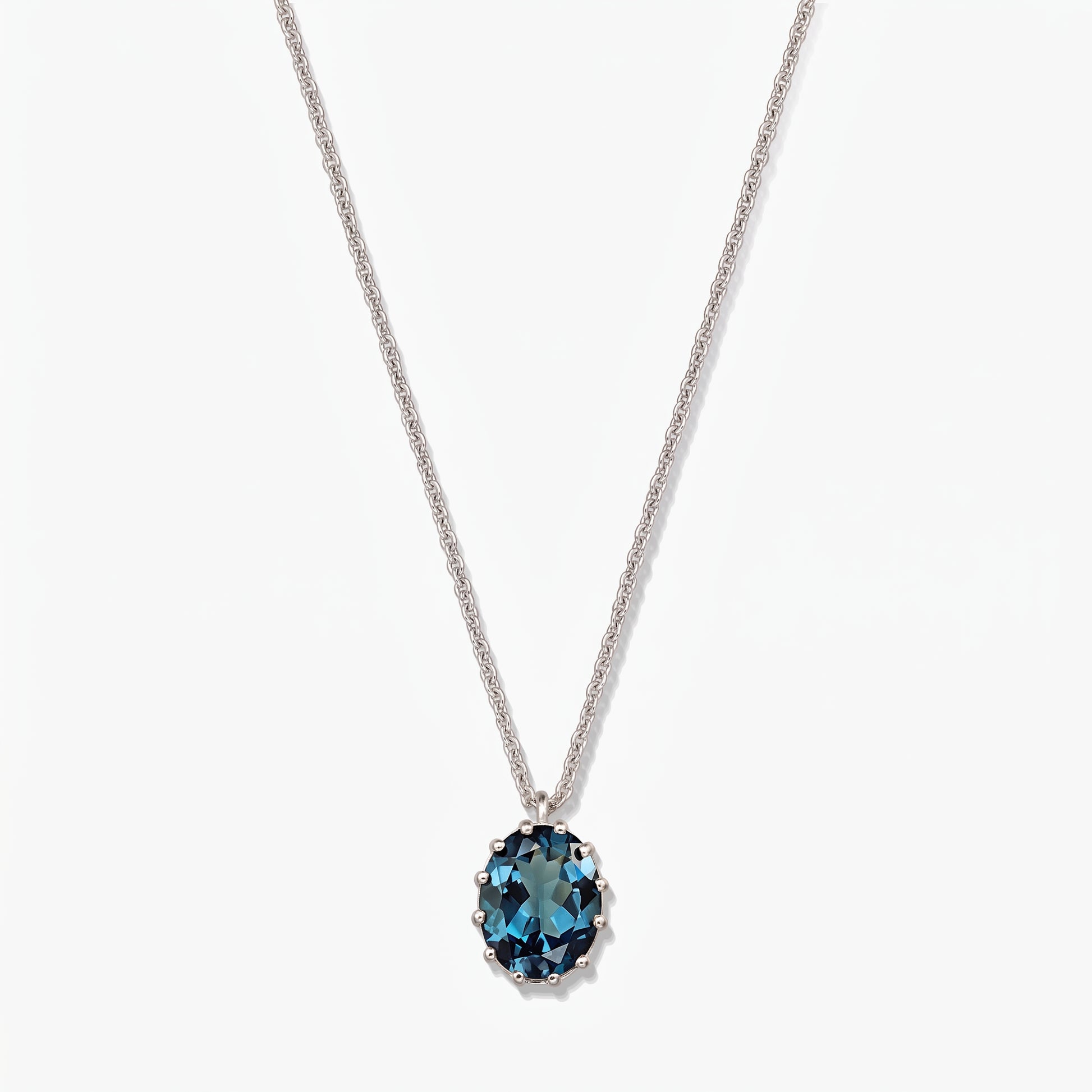 Elegant sterling silver necklace featuring an oval London blue topaz pendant on a white background.