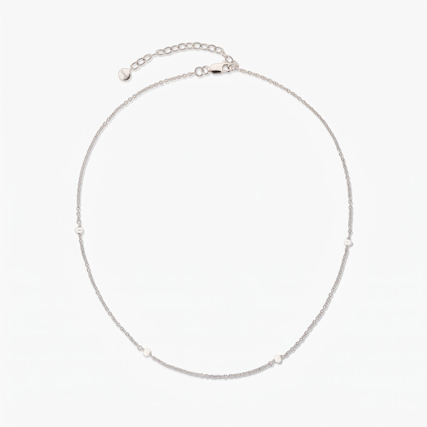 Collier chaîne en argent délicat avec de petites perles blanches espacées, présenté en cercle sur fond blanc avec une rallonge ajustable et un fermoir mousqueton.