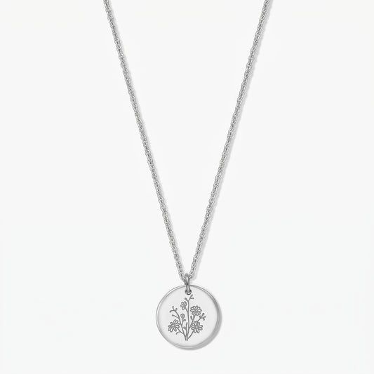 Birth flower silver necklace with a September aster–engraved round pendant in 925 silver on a delicate chain, isolated on a white background.