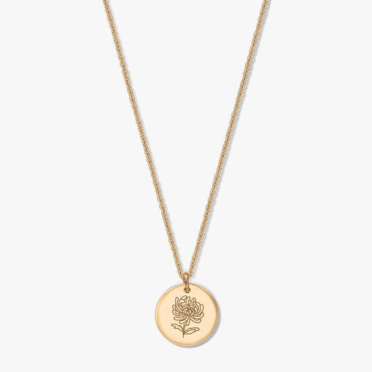 Collier en argent plaqué or avec pendentif rond en forme de pièce, gravé d’un chrysanthème, la fleur de naissance de novembre, sur fond blanc.