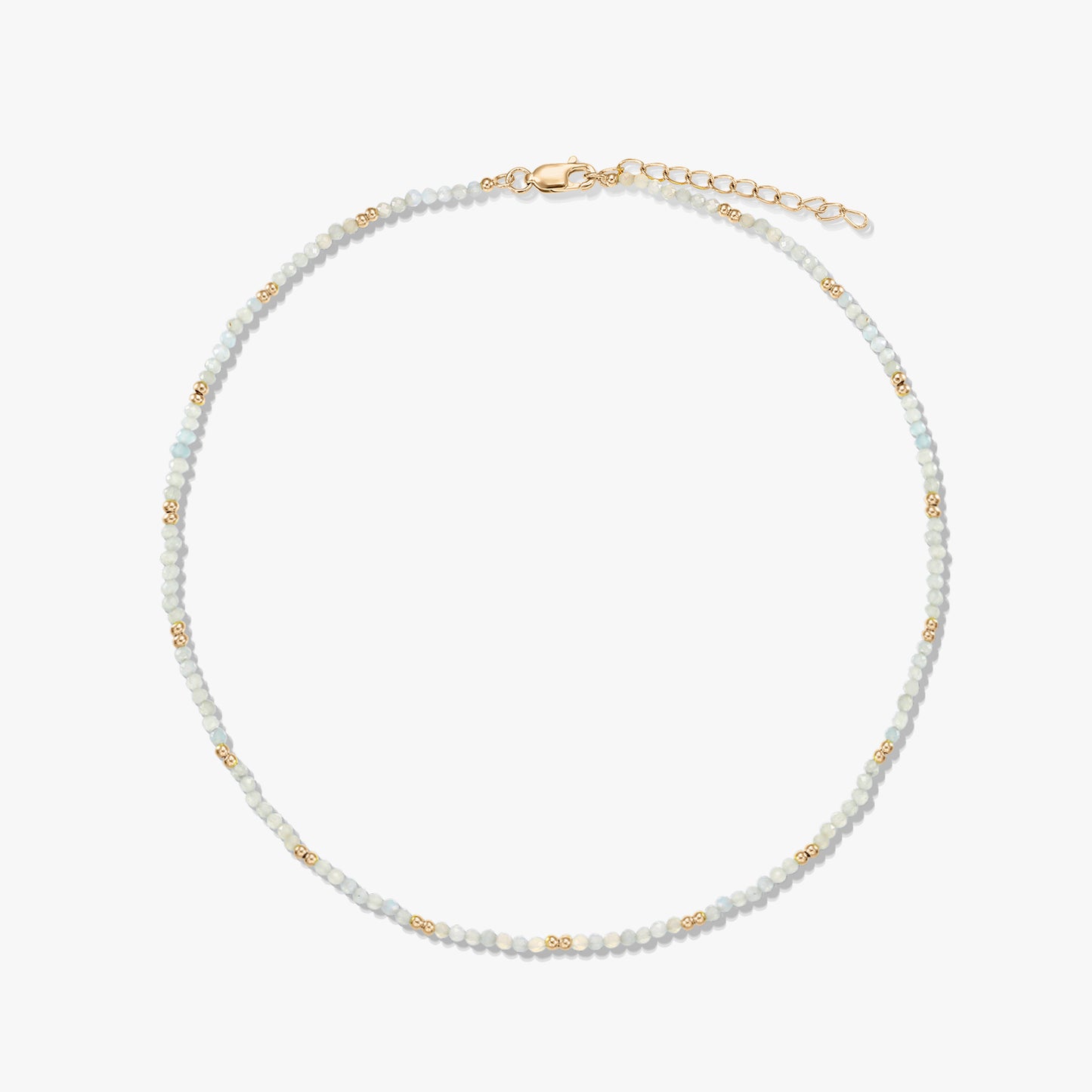 Delicate beaded moonstone necklace featuring small gold spacer beads and a gold‑plated sterling silver lobster clasp and extender, arranged in a circle on a white background.