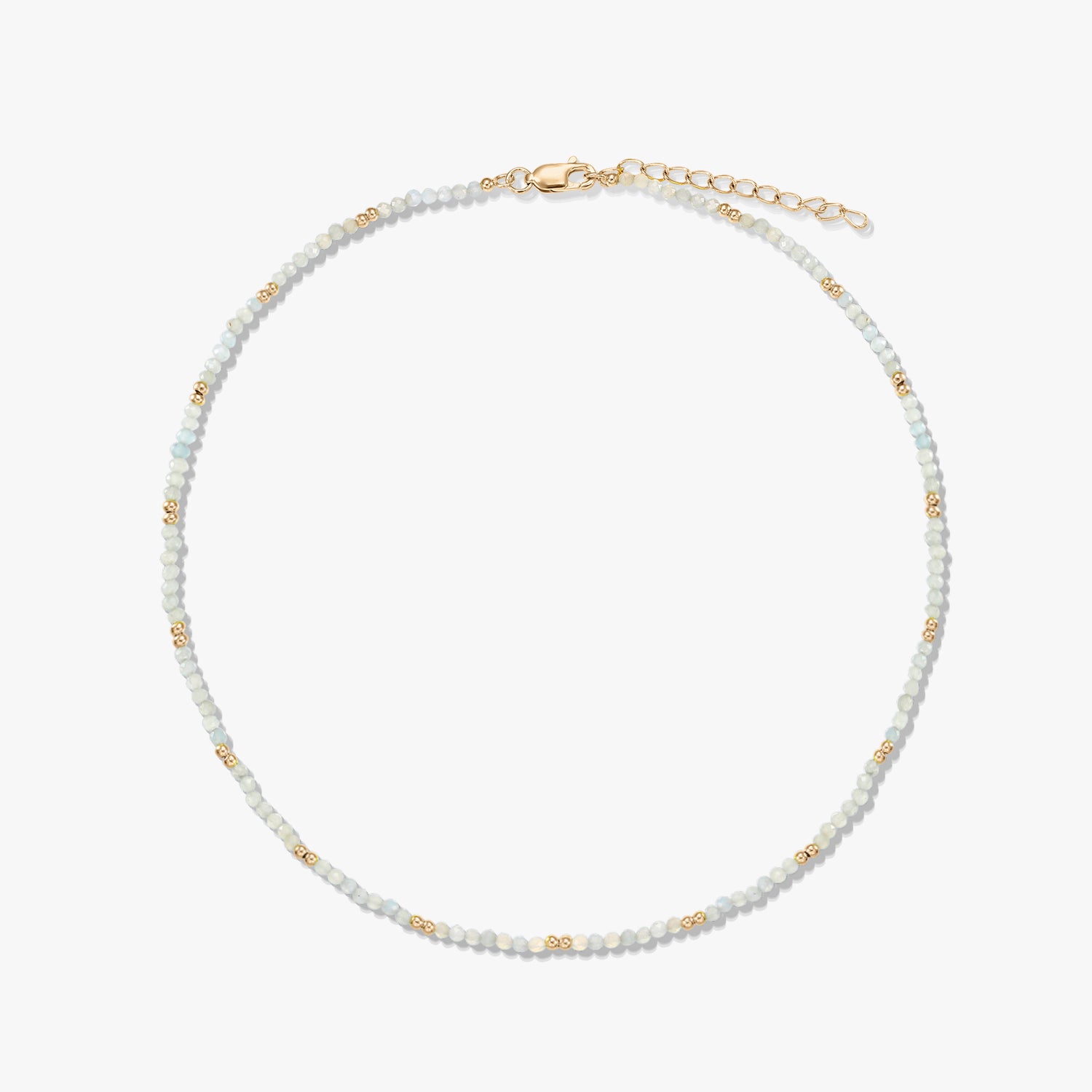 Delicate beaded moonstone necklace featuring small gold spacer beads and a gold‑plated sterling silver lobster clasp and extender, arranged in a circle on a white background.