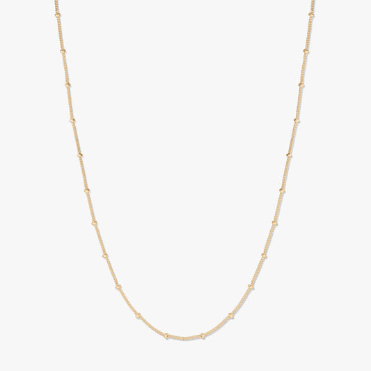 Elegant gold-plated silver beaded chain necklace on a white background, forming a gentle U-shape with delicate bead stations along the chain.
