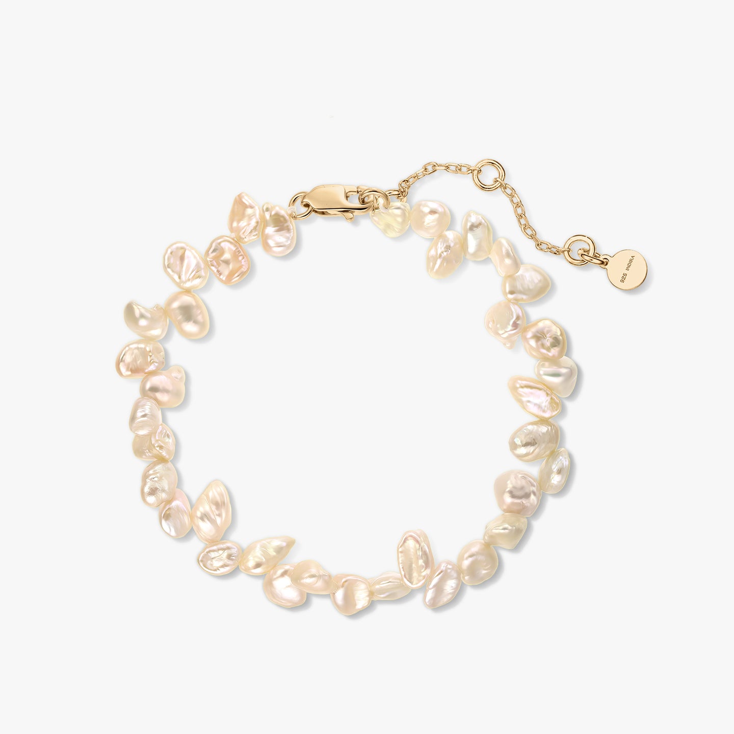 Gold-plated sterling silver bracelet with natural pink keshi pearls and an extender chain on a white background.