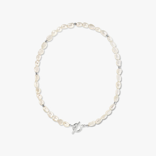 Centered studio photograph of a silver toggle-clasp necklace strung with natural white baroque pearls on a solid white background.