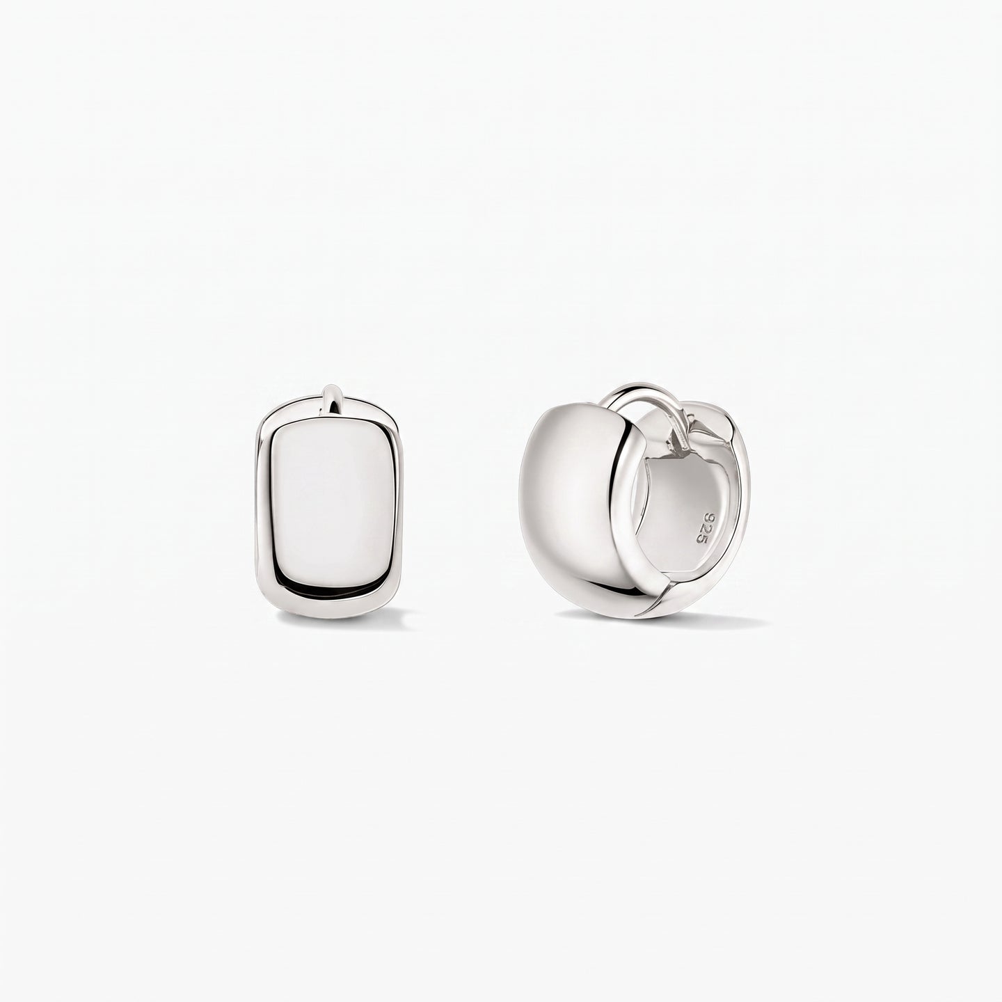 Indira Bold Mini Hoops ezüst karika fülbevalók 925-ös sterling ezüstből, fehér háttéren. Az egyik fülbevaló elölnézetben, a másik oldalnézetben látható, a csuklós kapocs jól kivehető.