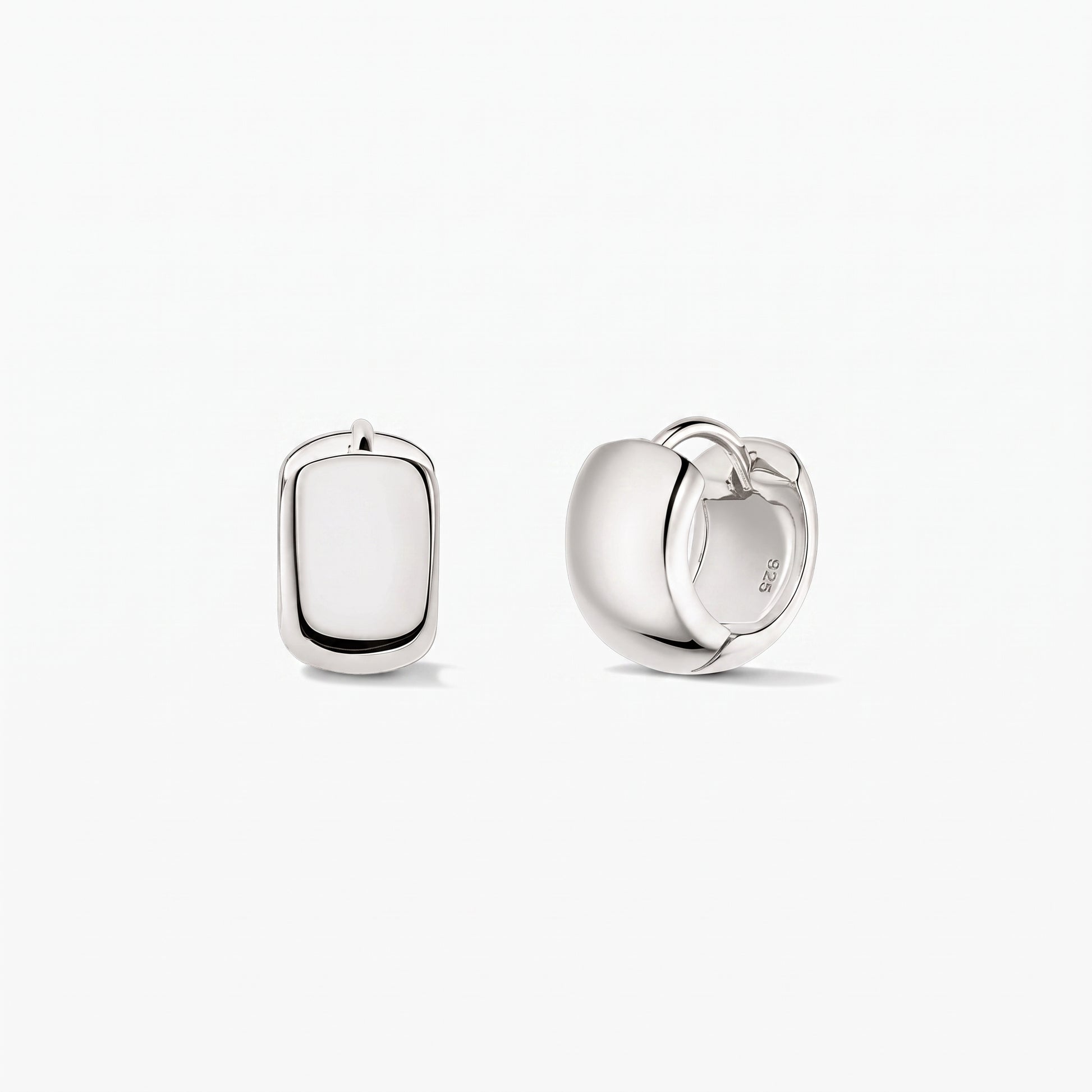 Indira Bold Mini Hoops ezüst karika fülbevalók 925-ös sterling ezüstből, fehér háttéren. Az egyik fülbevaló elölnézetben, a másik oldalnézetben látható, a csuklós kapocs jól kivehető.