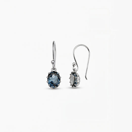 Elegant sterling silver drop earrings featuring oval London blue topaz gemstones on a white background.