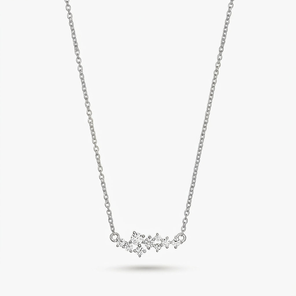 Delicate silver constellation necklace with small clear stones on a fine chain, isolated on a white background.