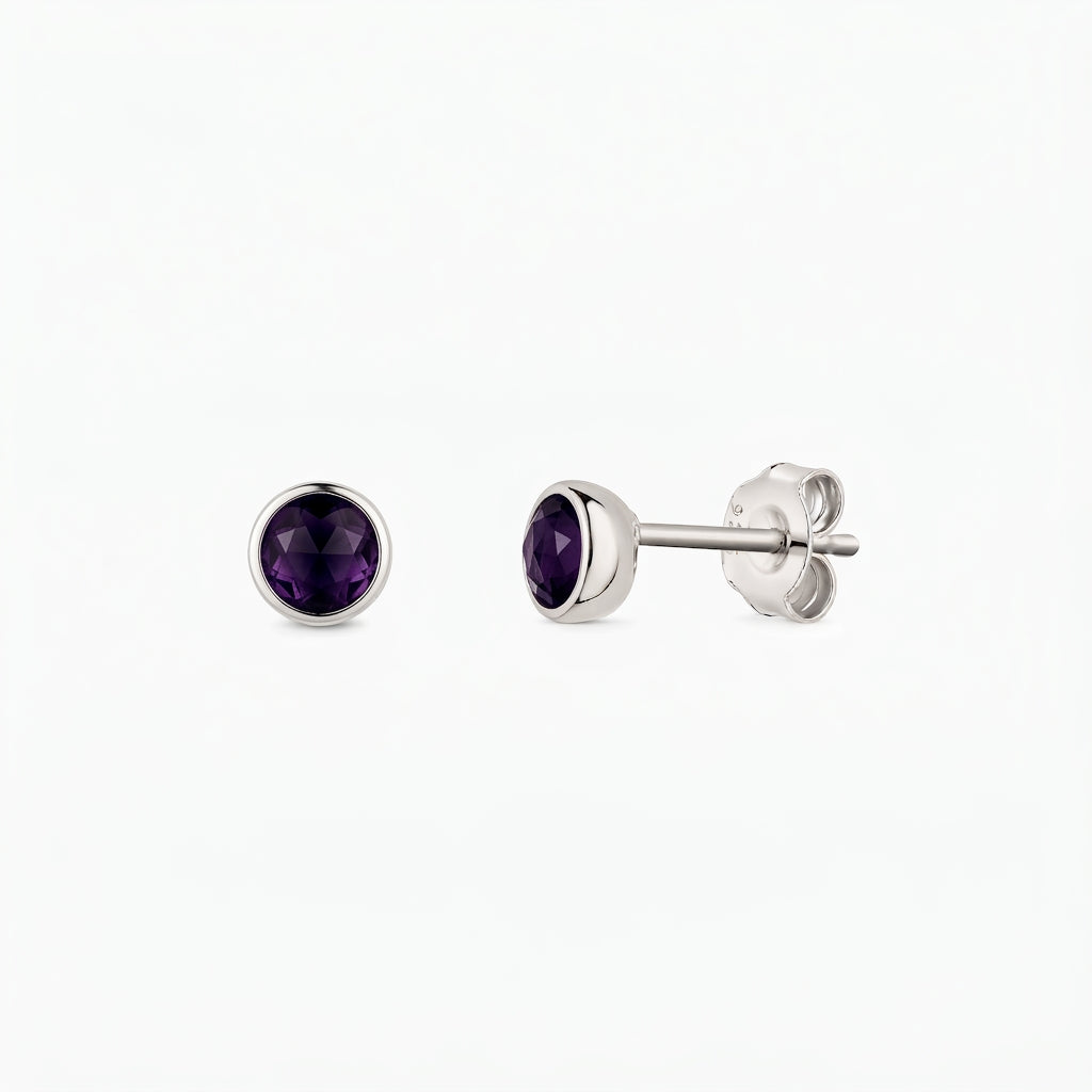 Paire de boucles d’oreilles puces en argent sterling avec pierres d’améthyste rondes facettées, serti clos, vues de face et de profil sur fond blanc.