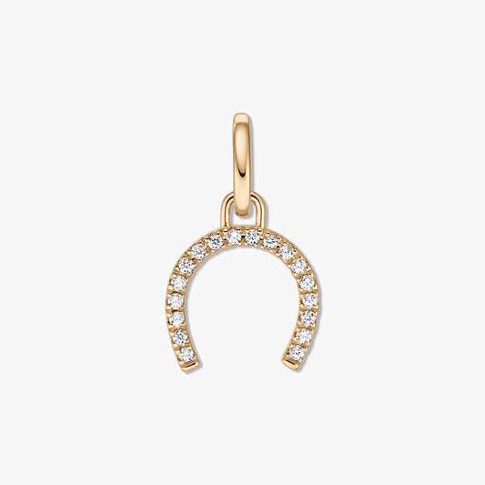 Silver horseshoe pendant in gold tone adorned with pavé clear zirconia stones on a white background.