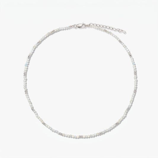 Delicate sterling silver necklace with small moonstone beads and an adjustable extender chain, photographed on a white background.