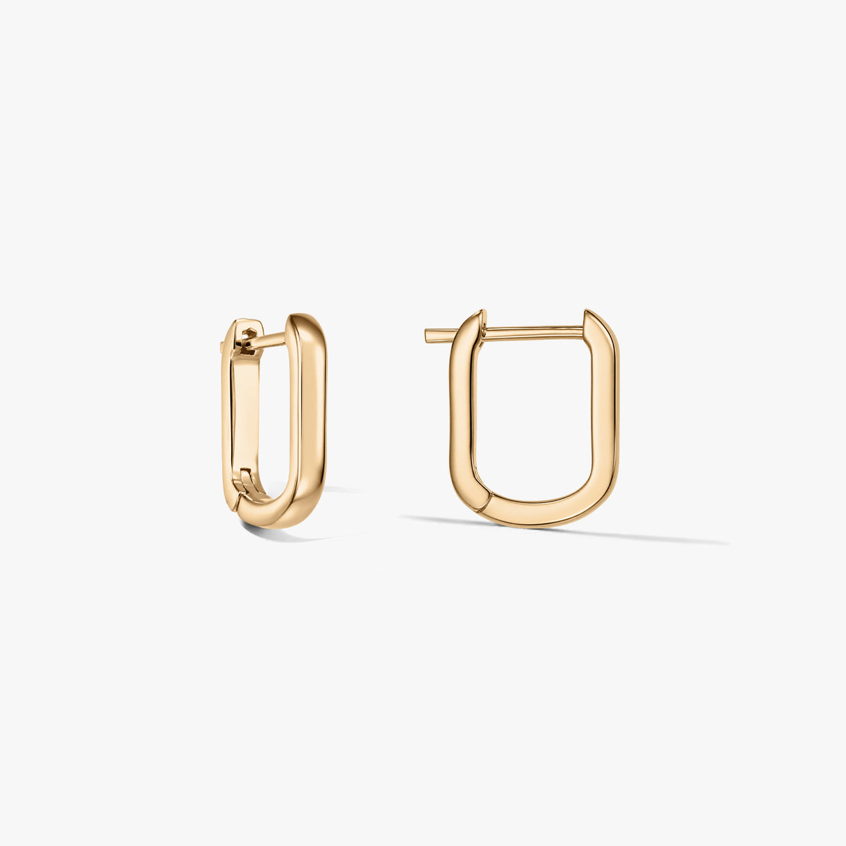 Paire de boucles d’oreilles créoles en argent sterling plaqué or, en forme de U, sur fond blanc, l’une ouverte, l’autre fermée.