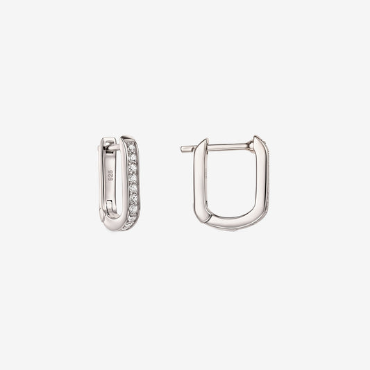 Paire de boucles d'oreilles créoles en argent sterling en forme de U avec pavé de zirconia clair, une ouverte pour montrer le fermoir à charnière, isolée sur fond blanc.