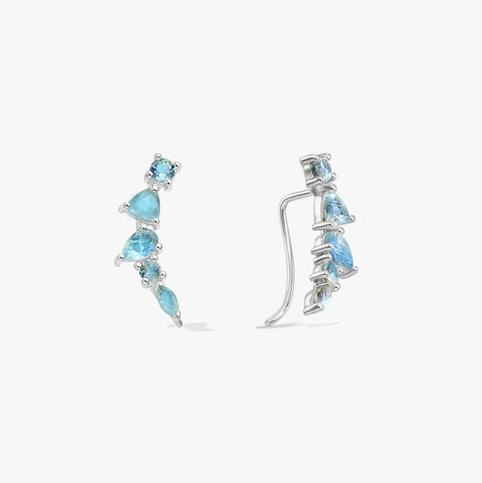 Paire de boucles d’oreilles ear climber en argent sterling ornées de pierres de labradorite bleues de tailles graduées, sur fond blanc, vues de face et de profil.