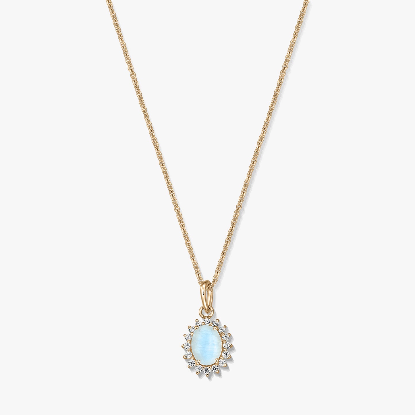 Gold‑plated sterling silver necklace with an oval light‑blue moonstone pendant framed by small clear stones on a white background.