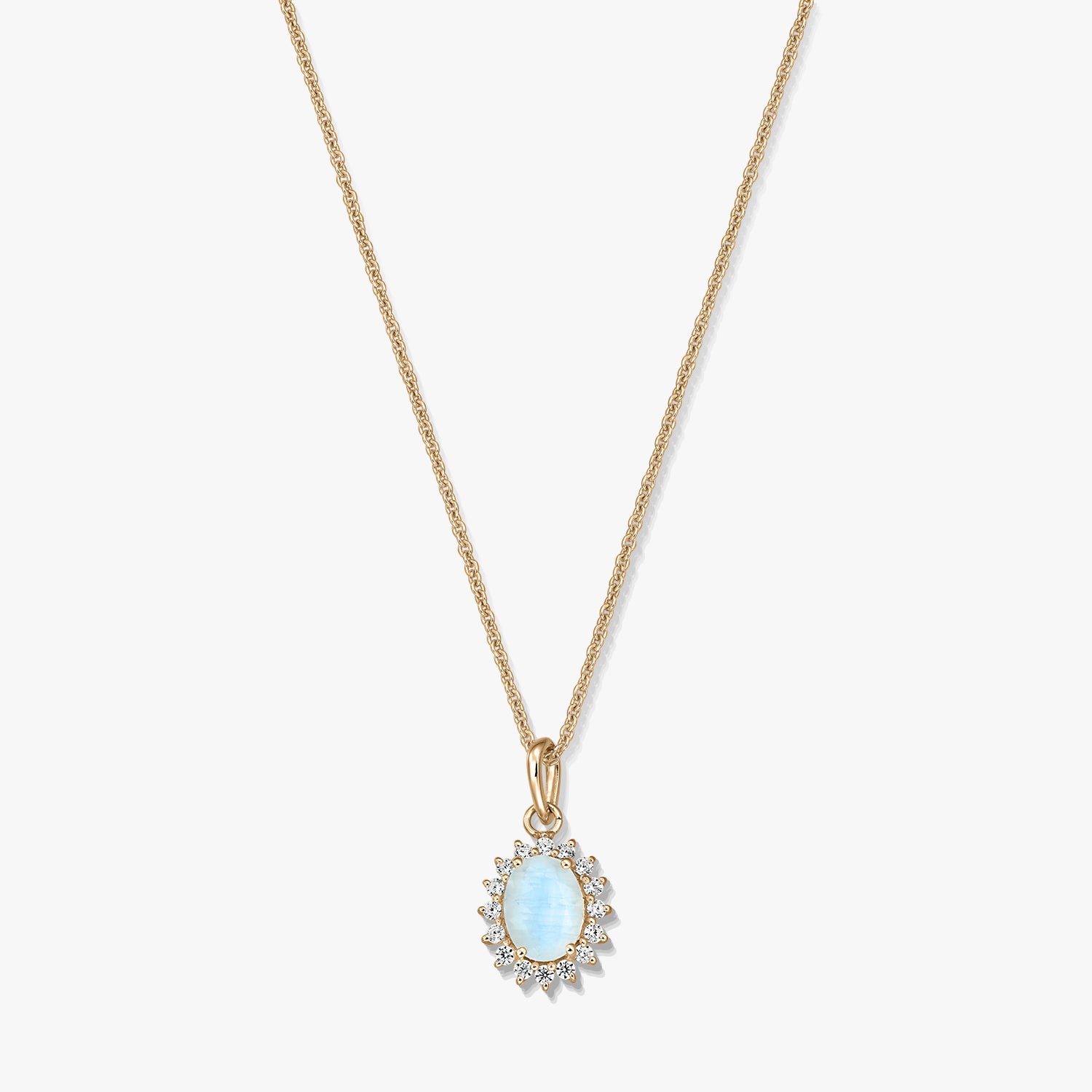 Gold‑plated sterling silver necklace with an oval light‑blue moonstone pendant framed by small clear stones on a white background.
