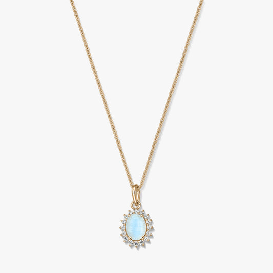 Gold‑plated sterling silver necklace with an oval light‑blue moonstone pendant framed by small clear stones on a white background.