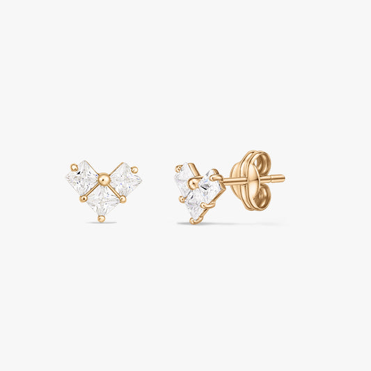 Paire de boucles d'oreilles clous en or jaune avec trois pierres carrées transparentes formant un petit groupe en forme de cœur, présentées sur fond blanc.