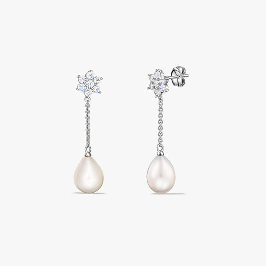 Pair of sterling silver drop earrings featuring teardrop-shaped cultured pearls suspended from a short chain, with a small sparkling cluster at the stud, on a white background.