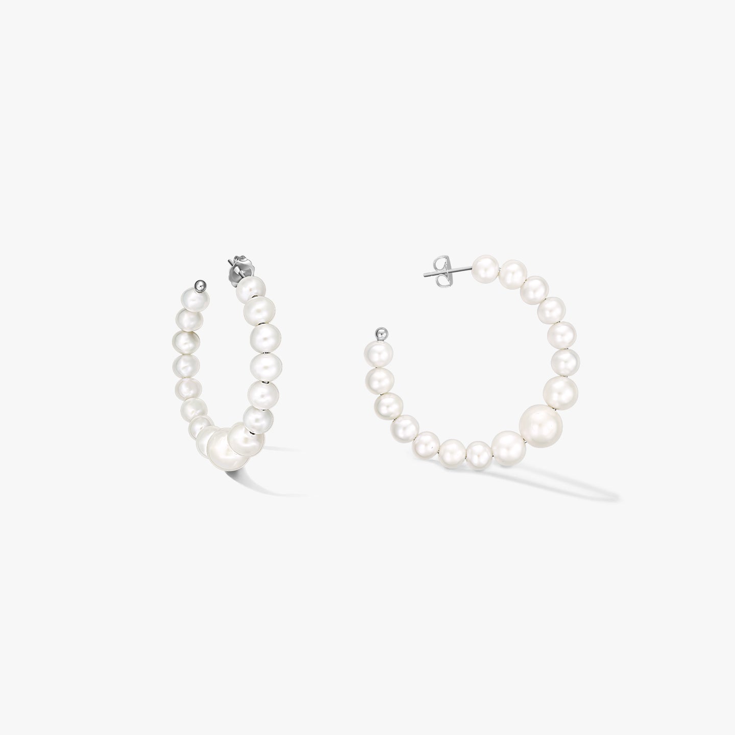 Pair of sterling-silver hoop earrings strung with graduated natural white pearls, shown on a white background.