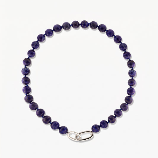 Photo carrée en studio du collier Mareille en argent avec des perles rondes de lapis-lazuli et un fermoir à maillons en argent poli sur fond blanc.