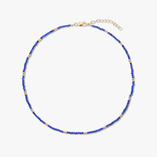 Delicate lapis lazuli beaded necklace with small gold‑plated sterling silver accents and an adjustable lobster clasp, isolated on a white background.