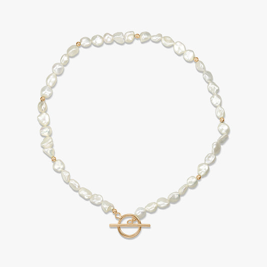 Silver necklace with natural pearls and a gold toggle clasp displayed on a white background.