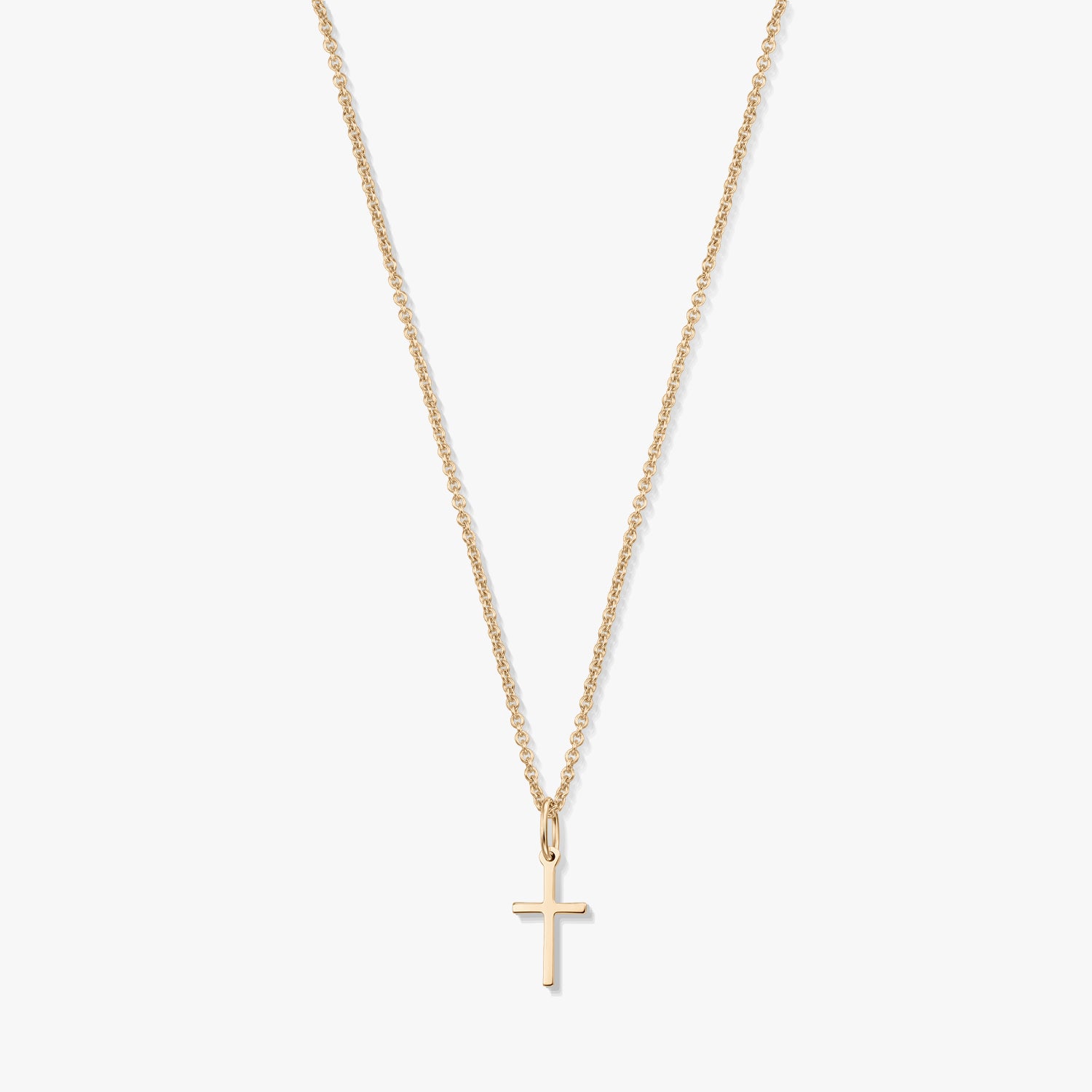 Minimalist 14K yellow gold necklace with a small cross pendant on a fine chain, isolated on a white background.