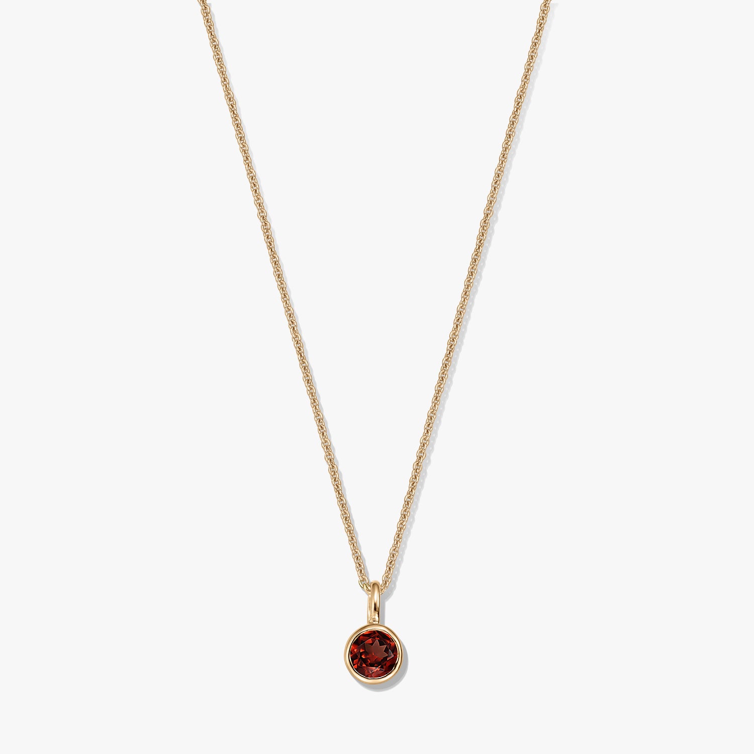 Gold-plated sterling silver birthstone necklace featuring a round bezel-set garnet pendant on a delicate chain, isolated on a white background.