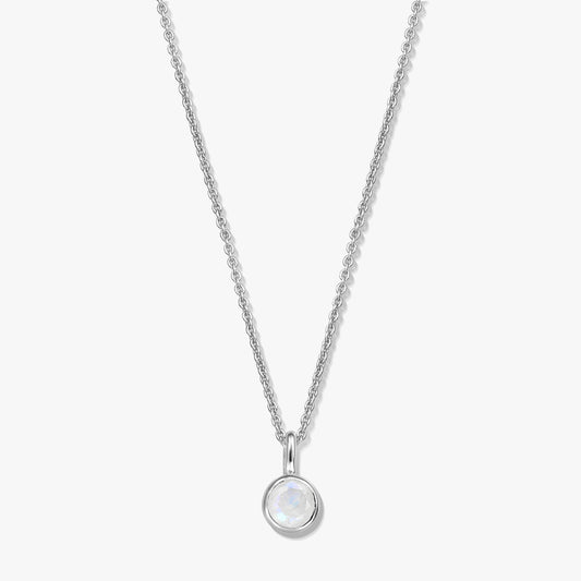 Elegant sterling silver birthstone necklace featuring a round bezel-set moonstone pendant on a fine chain, photographed on a white background.