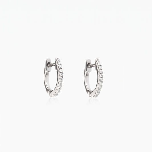 Pair of Sadie silver huggie hoop earrings with clear pavé zirconia on a white background.