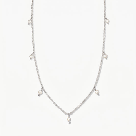 Collier en argent Indira Margot orné de petites gouttes de perles naturelles, photographié sur un fond blanc épuré.