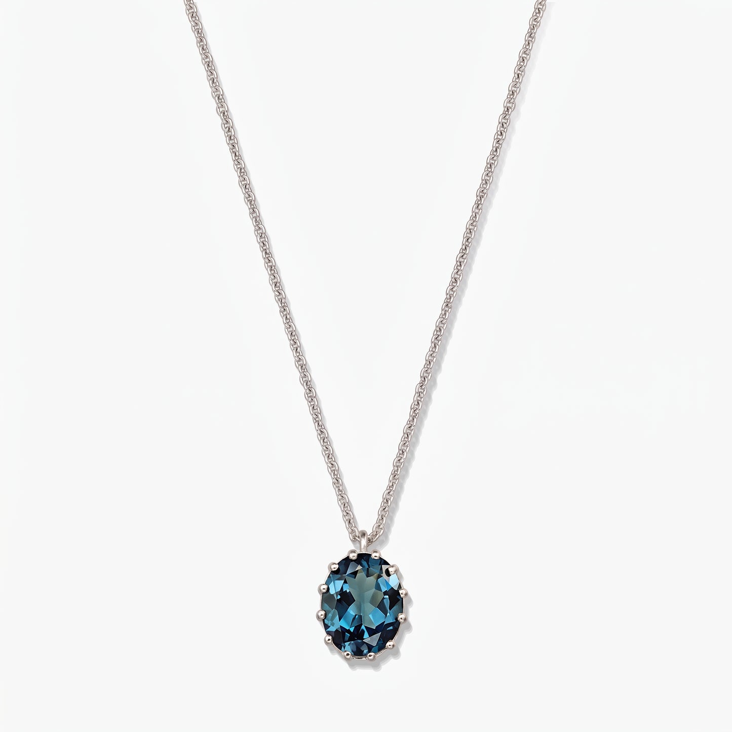 Elegant sterling silver necklace featuring an oval London blue topaz pendant on a white background.