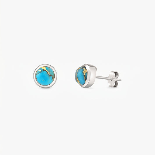 Paire de puces d’oreilles en argent sterling avec cabochons ronds de turquoise bleue cuivrée en serti clos, sur fond blanc.