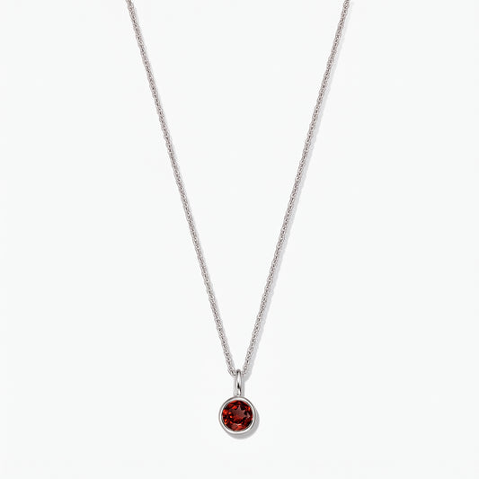Sterling silver birthstone necklace featuring a round bezel-set garnet pendant on a white background.