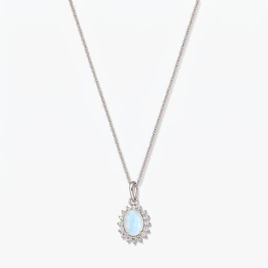 Sterling silver necklace with an oval light‑blue moonstone pendant framed by small clear stones on a fine chain, photographed on a white background.